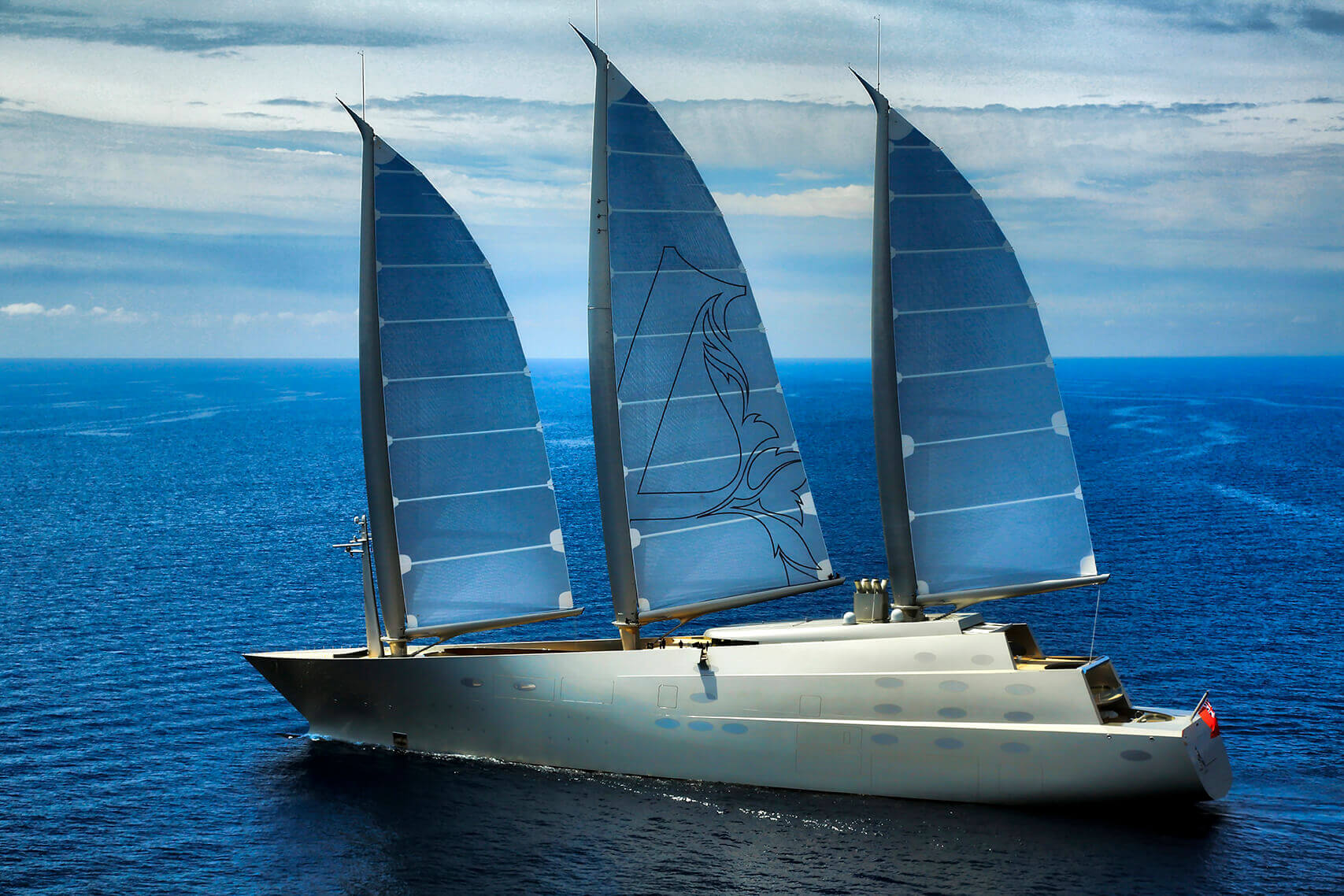 Large sail yacht cruising through clear blue waters 
